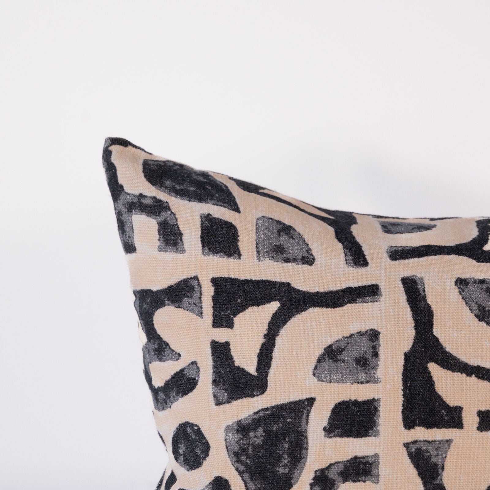 Decorative pillow with black abstract pattern on beige background