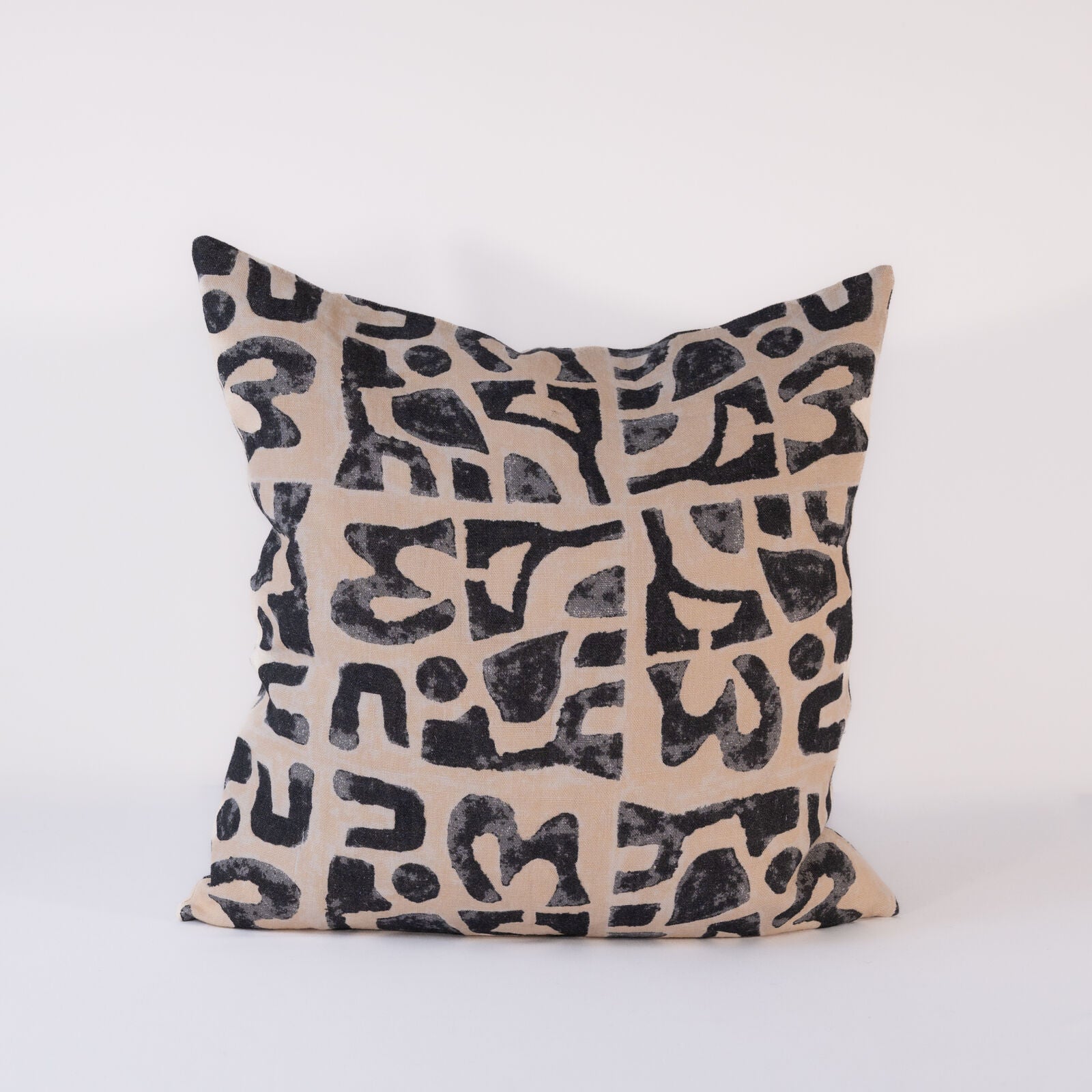Decorative pillow with black abstract pattern on beige background