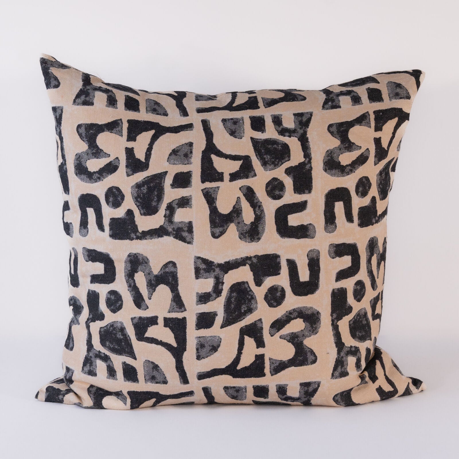 Decorative pillow with black abstract pattern on beige background