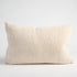 A beige coloured cushion on a white background