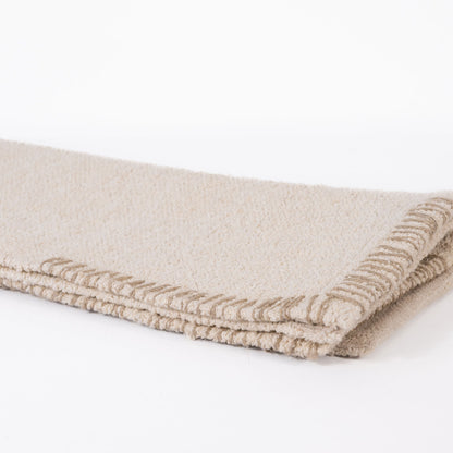 Cream or off white woven bathmat on a white background