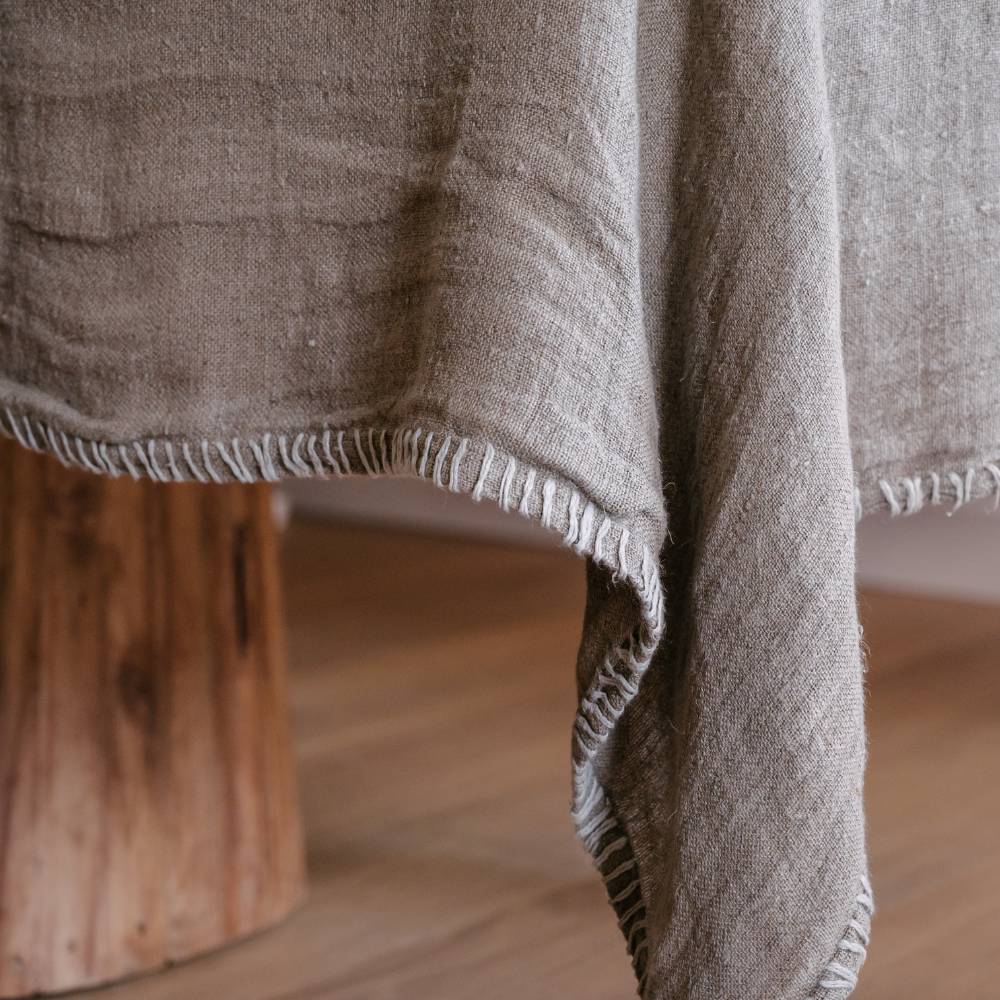 Beige textured tablecloth draped over a wooden table