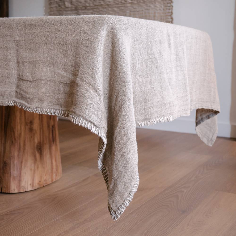 Beige textured tablecloth draped over a wooden table
