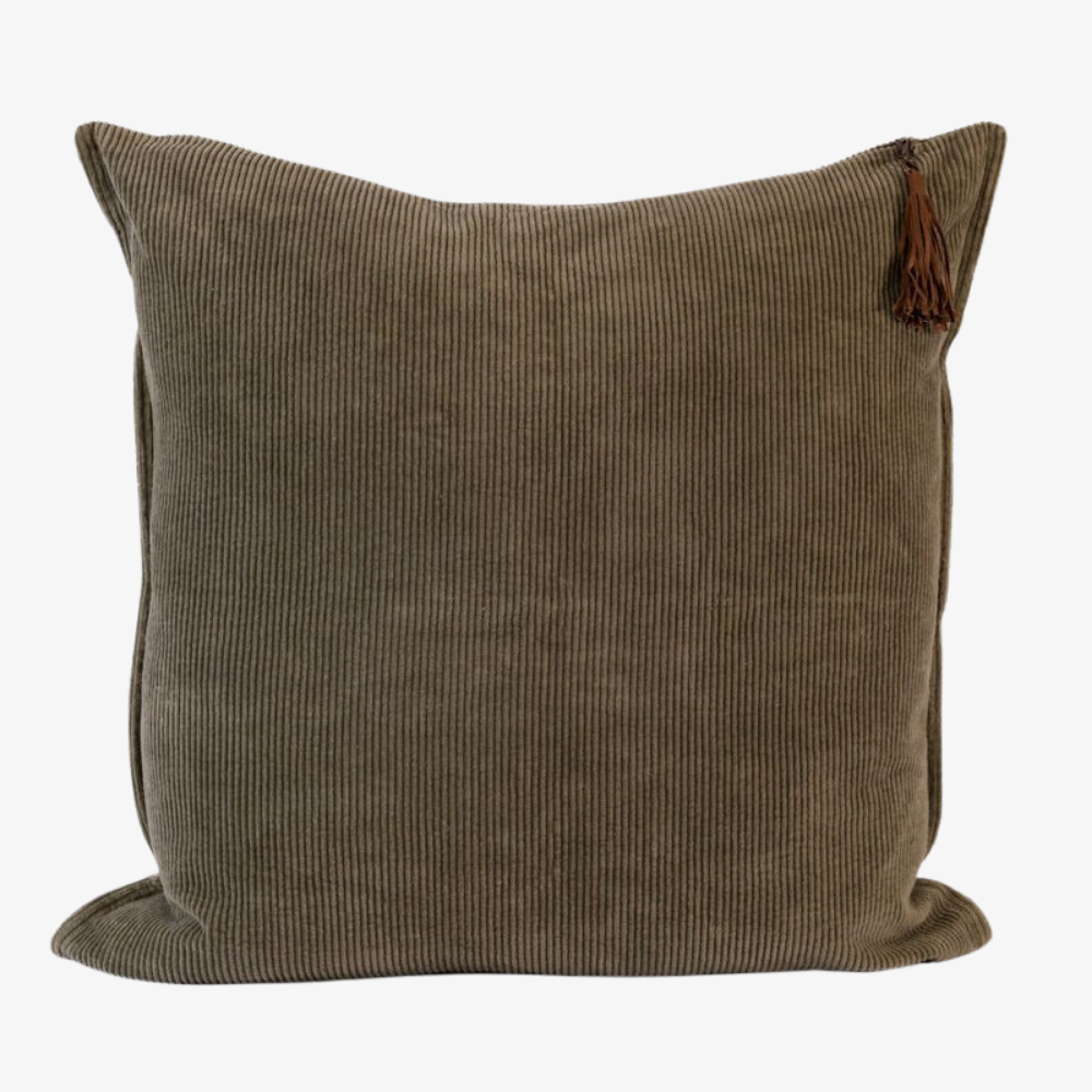 Dark green corduroy pillow with a tassel on a white background