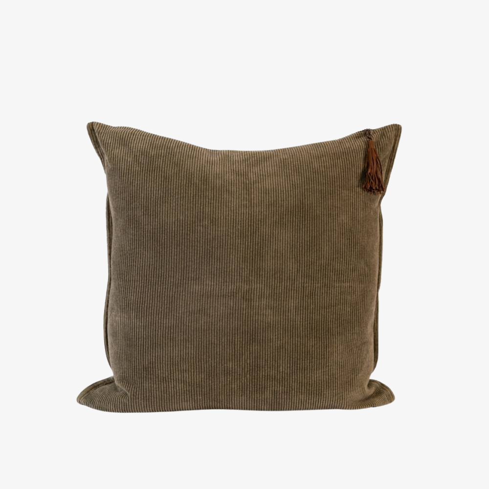 Dark green corduroy pillow with a tassel on a white background