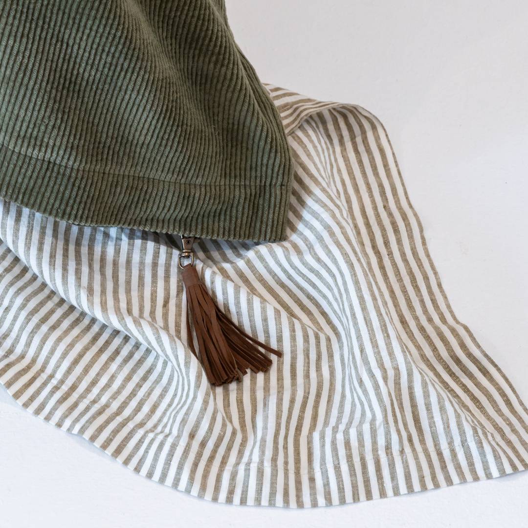 Dark green comforter on a bed in a bedroom with abstract art and decor.