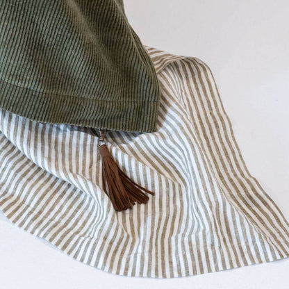 Dark green comforter on a bed in a bedroom with abstract art and decor.