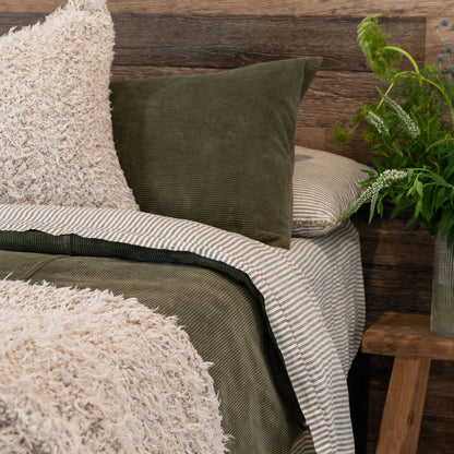 Green green comforter on a bed in a bedroom with abstract art and decor.