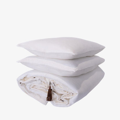 Stack of white pillows with a tassel on a white background