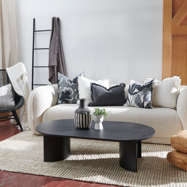 black white and slate inspired living room with linen cushions and throws on a boucle lounge