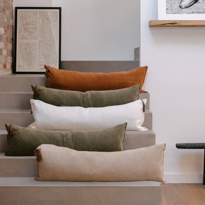 Set of long rectangular pillows in various colors on a staircase.