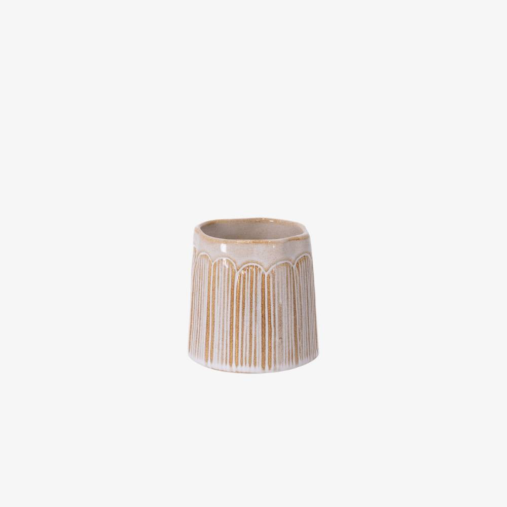 Ceramic planter with decorative lines on a white background