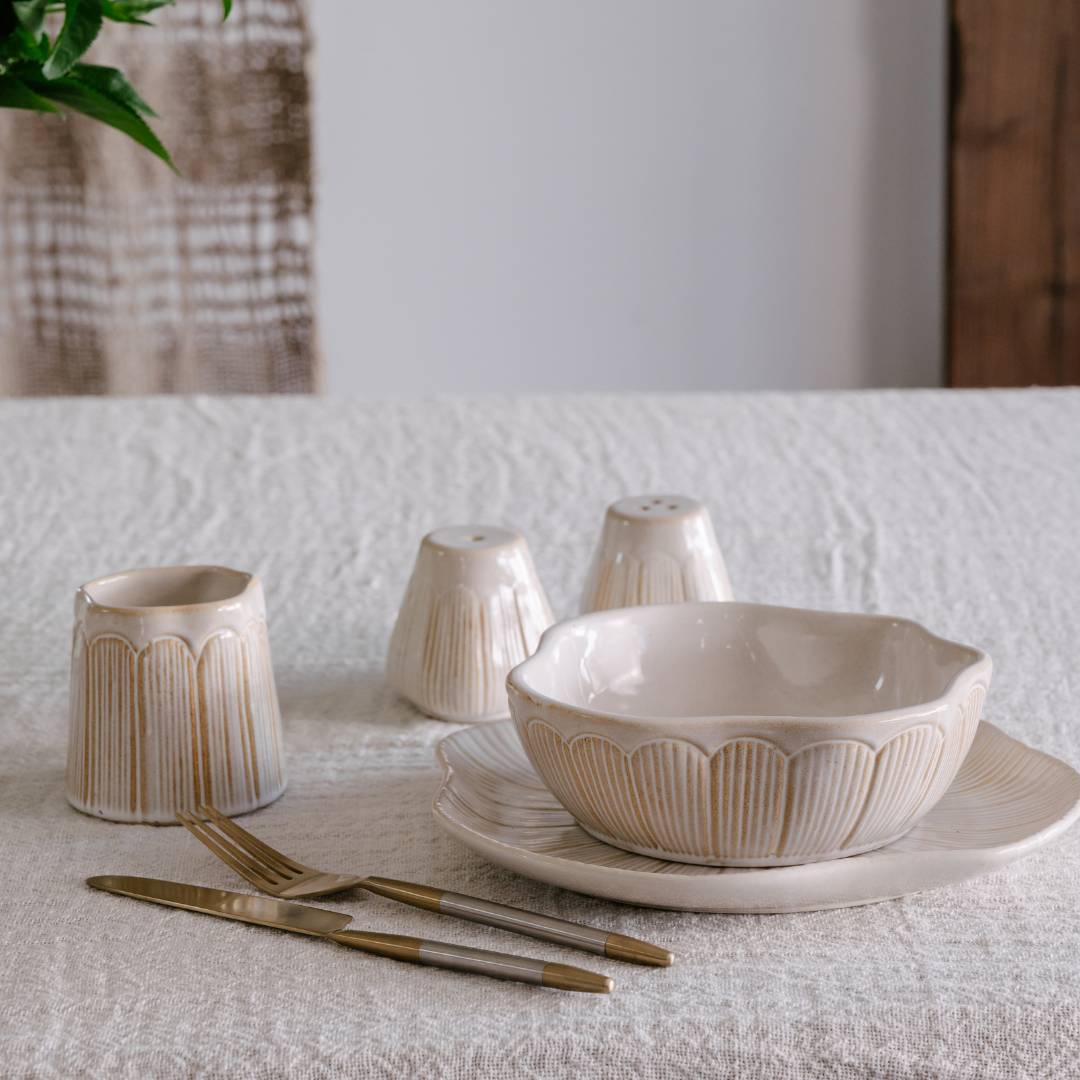Ceramic tableware set on a textured surface with a neutral background