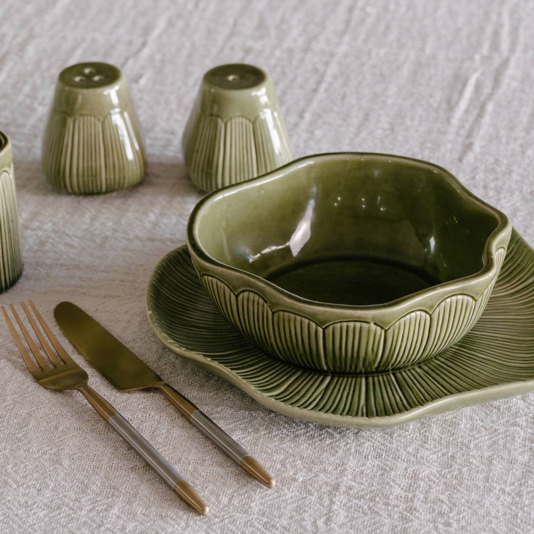 Green ceramic tableware set on a textured surface