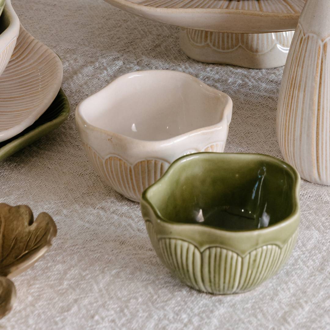 Green ceramic bowl with textured design on a textured surface