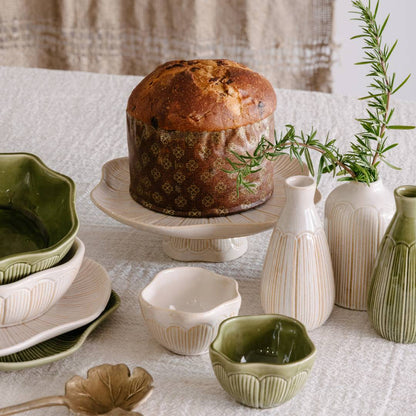 Decorative table setting with a loaf of bread, ceramic bowls, and vases.