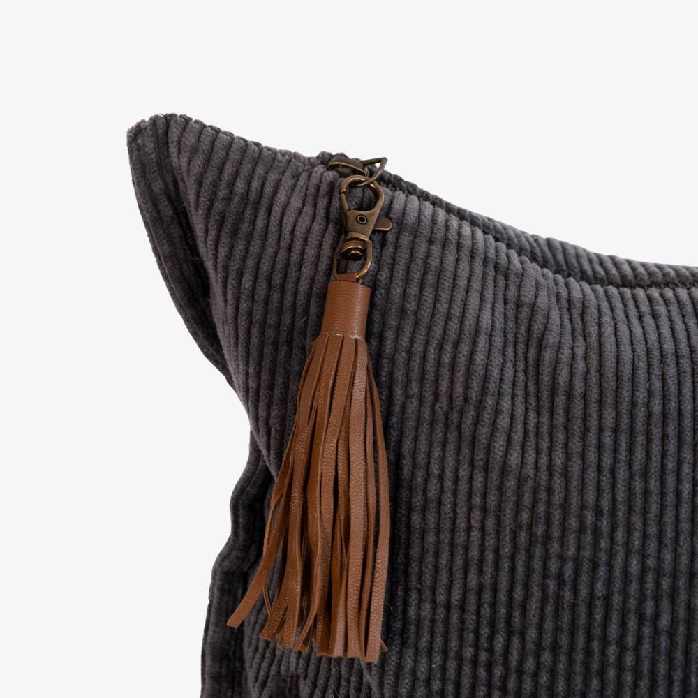 Gray pillow with a brown tassel keychain on a white background