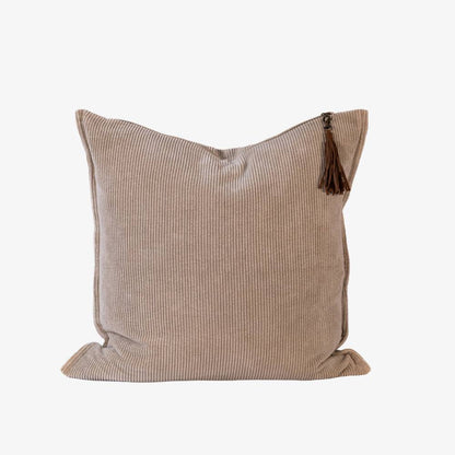 Beige pillow with a tassel on a white background