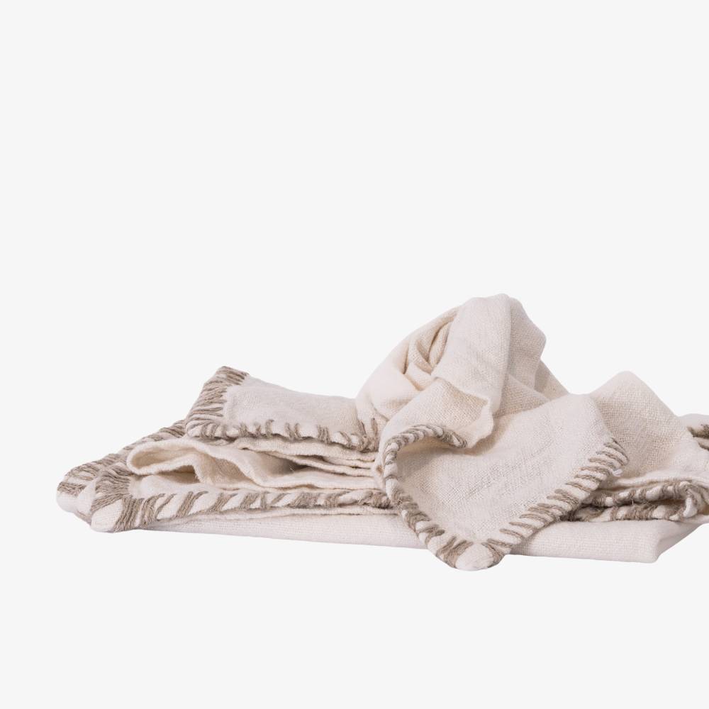 Beige blanket with brown trim on a white background