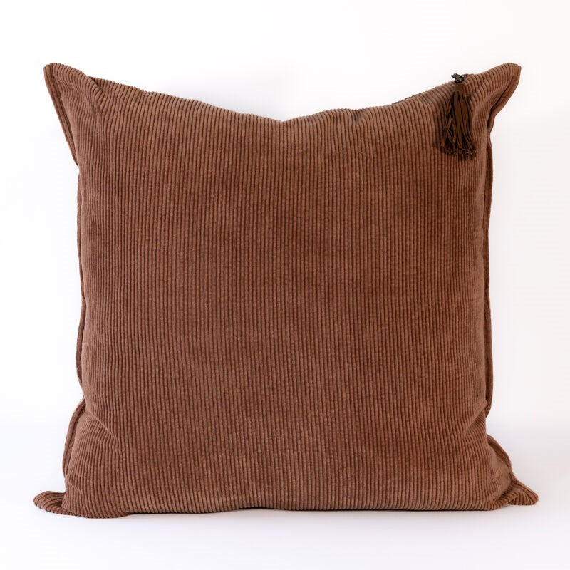 Brown textured pillow with tassels on a white background