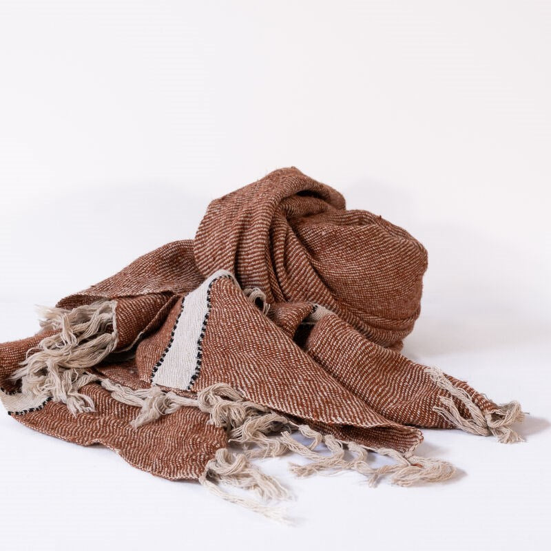 Brown woven blanket with fringes on a white background