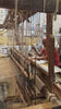 Artistan working on a hand-loom machine creating fabric 